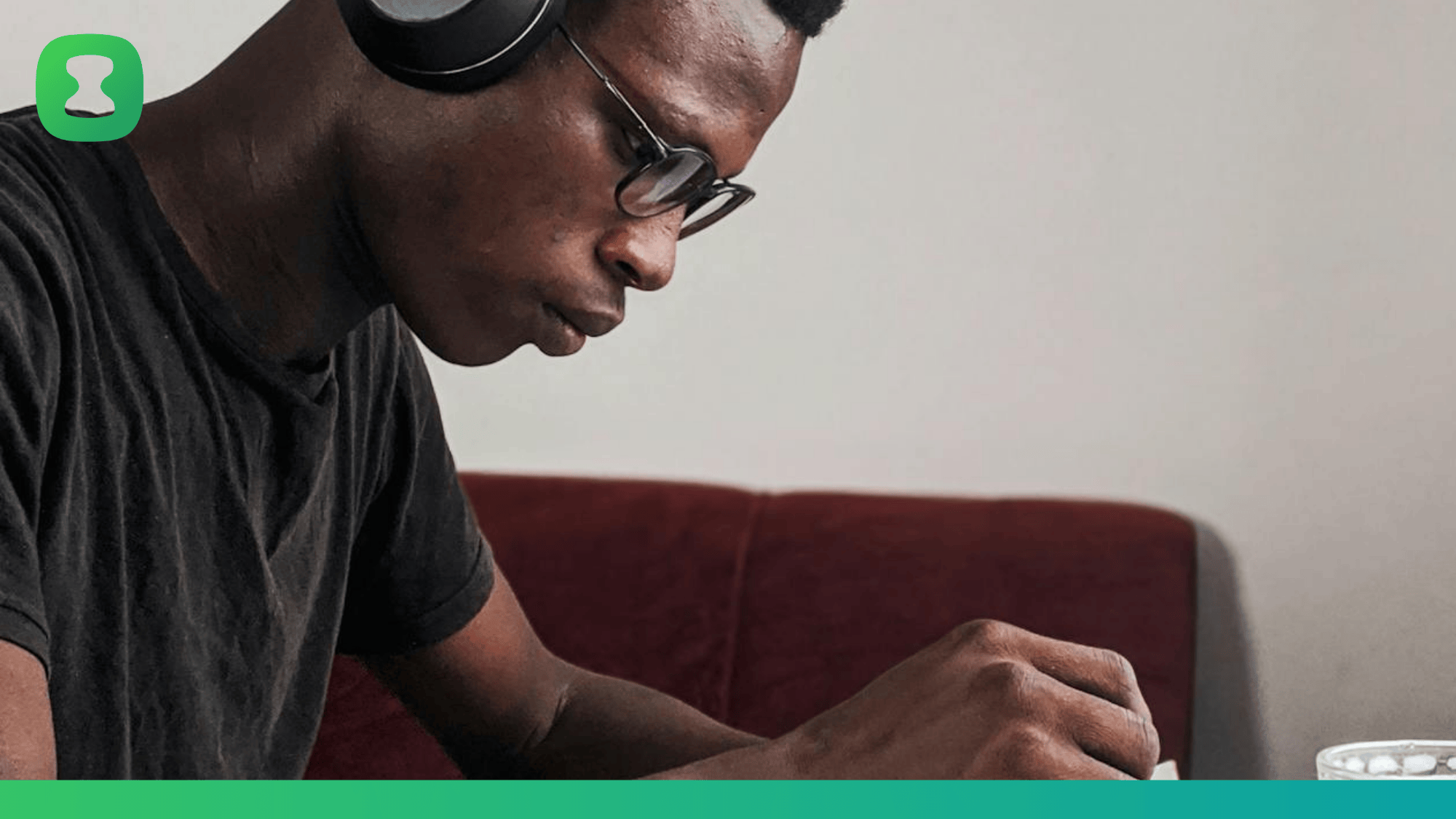 Photo by Oladimeji Ajegbile. Man is wearing a round collar t-shirt, with headphones on and working at a desk.