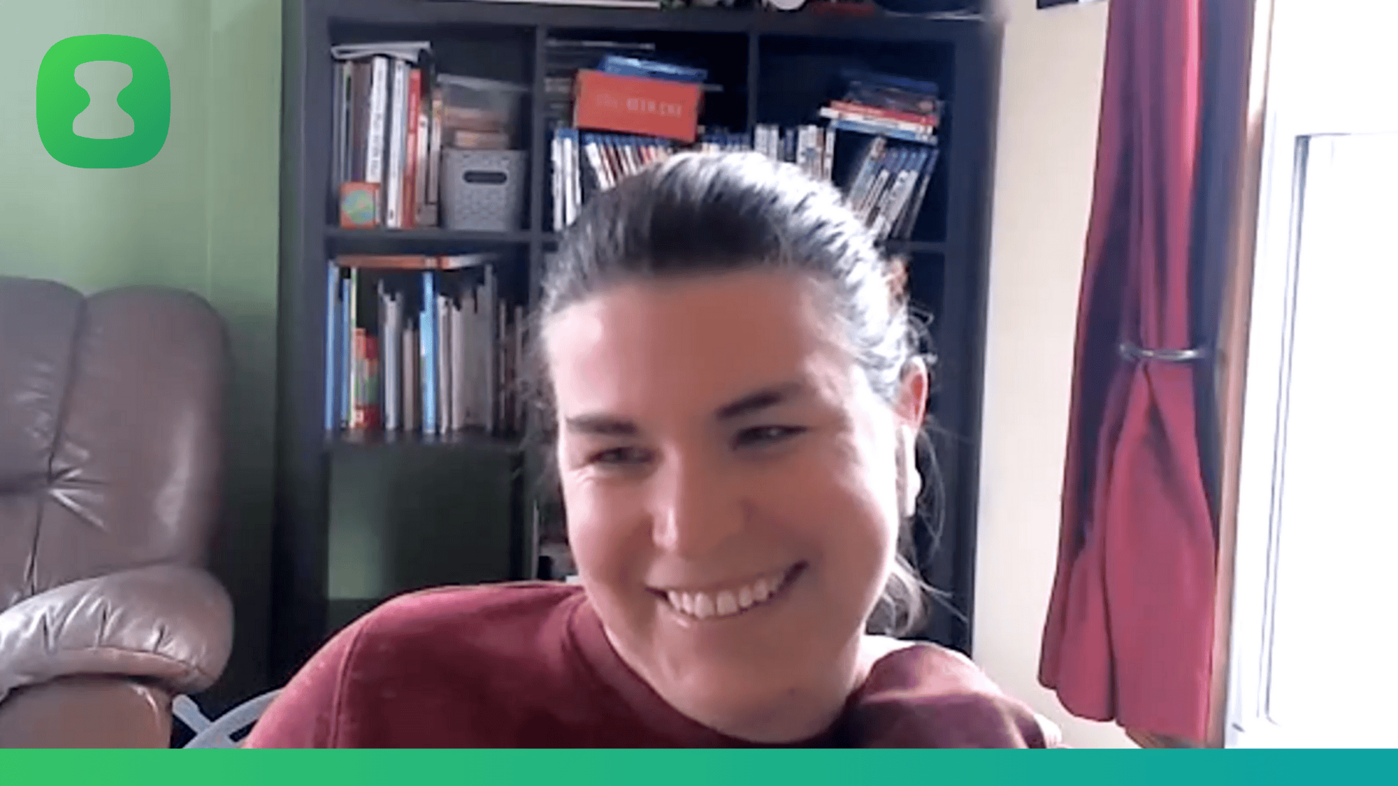 Beth smiling at her webcam as she converses with Clockk's founder, Paul Doerwald. She is wearing a red round neck sweatshirt. The topic of discussion is how Clockk's time tracker helps her be a better virtual assistant